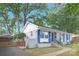 Charming one-story home with blue shutters, updated windows, grey brick, a walkway, and large shade trees at 1744 Emerywood Dr, Charlotte, NC 28210