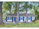 Inviting front exterior with freshly painted light grey brick, blue shutters, mature landscaping, and a well-manicured lawn at 1744 Emerywood Dr, Charlotte, NC 28210