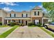 Inviting townhome showcasing a well-maintained lawn, brick accents, and a convenient carport for covered parking at 222 Ross Moore Ave, Charlotte, NC 28205