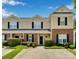 Charming townhome with a brick and tan siding, complemented by manicured landscaping and dark shutters at 222 Ross Moore Ave, Charlotte, NC 28205