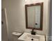 Bathroom features a toilet and a sink with bronze faucet and mirror with wood-look surround at 2448 Cambridge Dr, Lancaster, SC 29720