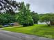 Landscaped yard with mature trees surrounding a charming single-story brick home at 2448 Cambridge Dr, Lancaster, SC 29720