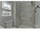 Updated bathroom featuring tile walls, hardwood floors, and natural light at 2706 Bremer Ct, Charlotte, NC 28210