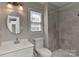 Bathroom featuring modern vanity, bathtub with shower, tile walls, and natural light at 2706 Bremer Ct, Charlotte, NC 28210