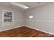 Bedroom featuring wood floors, natural light from skylight and window, and crisp white trim at 2706 Bremer Ct, Charlotte, NC 28210