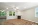 Cozy living room featuring a fireplace, ceiling fan, and large windows providing ample natural light at 3029 Marchers Trace Dr, Charlotte, NC 28227