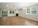 Bright living room featuring a fireplace, ceiling fan, large windows, and hardwood floors at 3029 Marchers Trace Dr, Charlotte, NC 28227