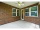 Outdoor patio area featuring brick siding, a fan, white trim, and ample light with concrete flooring at 3029 Marchers Trace Dr, Charlotte, NC 28227