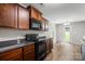This modern kitchen showcases black appliances, ample counter space, and wooden cabinets, ideal for cooking enthusiasts at 329 Brannon Meadows Dr, York, SC 29745