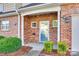 Inviting brick entryway with a storm door and manicured bushes at 349 Valley Brook Se Ln, Concord, NC 28025