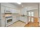 All-white kitchen open to the living room featuring laminate floors at 349 Valley Brook Se Ln, Concord, NC 28025