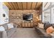 Cozy living room with wood-paneled ceiling, brick walls, modern furnishings, and natural light at 364 Catalina Dr, Mooresville, NC 28117