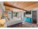 Bright main bedroom featuring a wooden ceiling, brick wall, and sliding door to the yard at 364 Catalina Dr, Mooresville, NC 28117