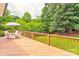 Large back deck with outdoor dining area surrounded by mature trees and lush greenery at 3874 Willow Grove Ln, Concord, NC 28025
