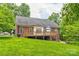 View of the back of the home with a large deck and spacious, green lawn area at 3874 Willow Grove Ln, Concord, NC 28025