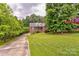 Charming brick home featuring a well-manicured lawn and a long driveway, surrounded by lush greenery at 3874 Willow Grove Ln, Concord, NC 28025