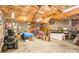 Large garage area with unfinished ceiling, lawnmower, and assorted street and commercial signage at 3874 Willow Grove Ln, Concord, NC 28025