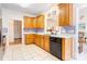 Kitchen featuring oak cabinets, tile floor, and a modern black dishwasher at 3874 Willow Grove Ln, Concord, NC 28025