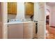 Well-lit laundry room with overhead cabinets and full-sized, white washer and dryer at 3874 Willow Grove Ln, Concord, NC 28025