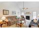 Cozy living room with fireplace, plush seating, and a ceiling fan at 3874 Willow Grove Ln, Concord, NC 28025