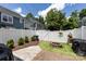 Private backyard featuring a stone fire pit, manicured lawn, string lights, and a white privacy fence at 432 W Worthington Ave, Charlotte, NC 28203