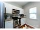 Cozy kitchen featuring stainless steel appliances, white cabinets, and granite countertops at 432 W Worthington Ave, Charlotte, NC 28203