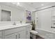 Well-lit bathroom featuring a white vanity with modern fixtures and a shower-tub combination with a decorative shower curtain at 517 Morrows Turnout Way, Pineville, NC 28134