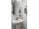 Bathroom featuring a sleek pedestal sink with modern fixtures, complemented by an oval mirror and towel hooks at 517 Morrows Turnout Way, Pineville, NC 28134