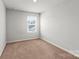 Bright bedroom with a window providing natural light and neutral carpeted floors, a cozy and inviting space at 517 Morrows Turnout Way, Pineville, NC 28134