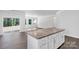 Kitchen island with a granite countertop and lots of cabinet space, next to open living space at 5244 Admirals Lndg, Lancaster, SC 29720