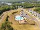 Aerial view of a sparkling community pool and playground, nestled among lush trees and beautiful homes near a lake at 5244 Admirals Lndg, Lancaster, SC 29720