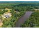 Aerial view of home with lake, surrounded by dense forest providing a sense of seclusion at 537 Riddle Mill Rd, Clover, SC 29710