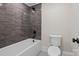 Modern bathroom featuring stylish tile, a soaking tub with matte black fixtures, and a standard white toilet at 537 Riddle Mill Rd, Clover, SC 29710