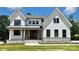 Charming two-story home with white siding, black trim windows, stone accents and covered front porch at 537 Riddle Mill Rd, Clover, SC 29710
