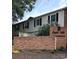 Exterior view of condo with brick base, gray siding, and black shutters in a meticulously maintained community at 5941 Quail Hollow Rd # F, Charlotte, NC 28210
