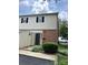 Exterior of home with black door, brick facade, tan vinyl siding, and green shrubs at base at 5941 Quail Hollow Rd # F, Charlotte, NC 28210