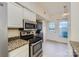 Efficient kitchen showcasing stainless steel appliances, granite counters, and access to the utility room at 5941 Quail Hollow Rd # F, Charlotte, NC 28210
