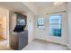 Bright laundry area features stacked washer and dryer, door to backyard, and tiled floors at 5941 Quail Hollow Rd # F, Charlotte, NC 28210