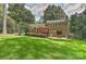 Backyard featuring a well-manicured lawn, deck, grill, and brick details for outdoor living at 6117 Yellowood Rd, Charlotte, NC 28210