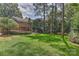 Lush green backyard with mature trees, a wooden deck, and manicured landscaping for serene outdoor enjoyment at 6117 Yellowood Rd, Charlotte, NC 28210
