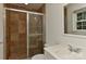 Bathroom features a shower with glass doors and brown tiled walls at 6117 Yellowood Rd, Charlotte, NC 28210