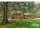 Charming two-story brick home with a well-manicured lawn, mature trees, and classic black shutters at 6117 Yellowood Rd, Charlotte, NC 28210