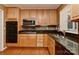 Bright kitchen with maple cabinetry, dark countertops, and stainless steel appliances at 6117 Yellowood Rd, Charlotte, NC 28210