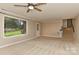 Living room featuring a large window, a door, stairs, and tan walls at 6117 Yellowood Rd, Charlotte, NC 28210