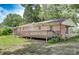 Expansive back yard with a wooden deck, showcasing the exterior of the brick home with well-maintained lawn and mature trees at 617 Oak Grove Rd, Kings Mountain, NC 28086