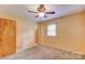 Bright bedroom features neutral walls, carpet, ceiling fan, window, and access to other rooms, providing a cozy living space at 617 Oak Grove Rd, Kings Mountain, NC 28086