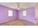 Bright bedroom with ceiling fan, two windows, and carpeted floors at 617 Oak Grove Rd, Kings Mountain, NC 28086