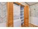Convenient laundry closet with a stacked washer and dryer unit and shelving for storage, optimizing space and functionality at 617 Oak Grove Rd, Kings Mountain, NC 28086