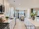 Open kitchen with white cabinets, countertops, stainless appliances, island and view to dining area at 6352 Fairfax Ct, Maiden, NC 28650