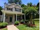 Charming two-story home with covered front porch, lush landscaping, and inviting curb appeal at 725 Chelton Ln, Fort Mill, SC 29715